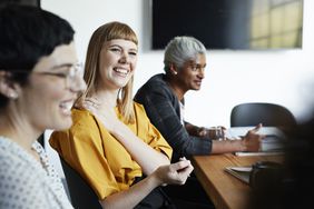 Co-workers discuss their 401(k) program at work during an HR meeting.