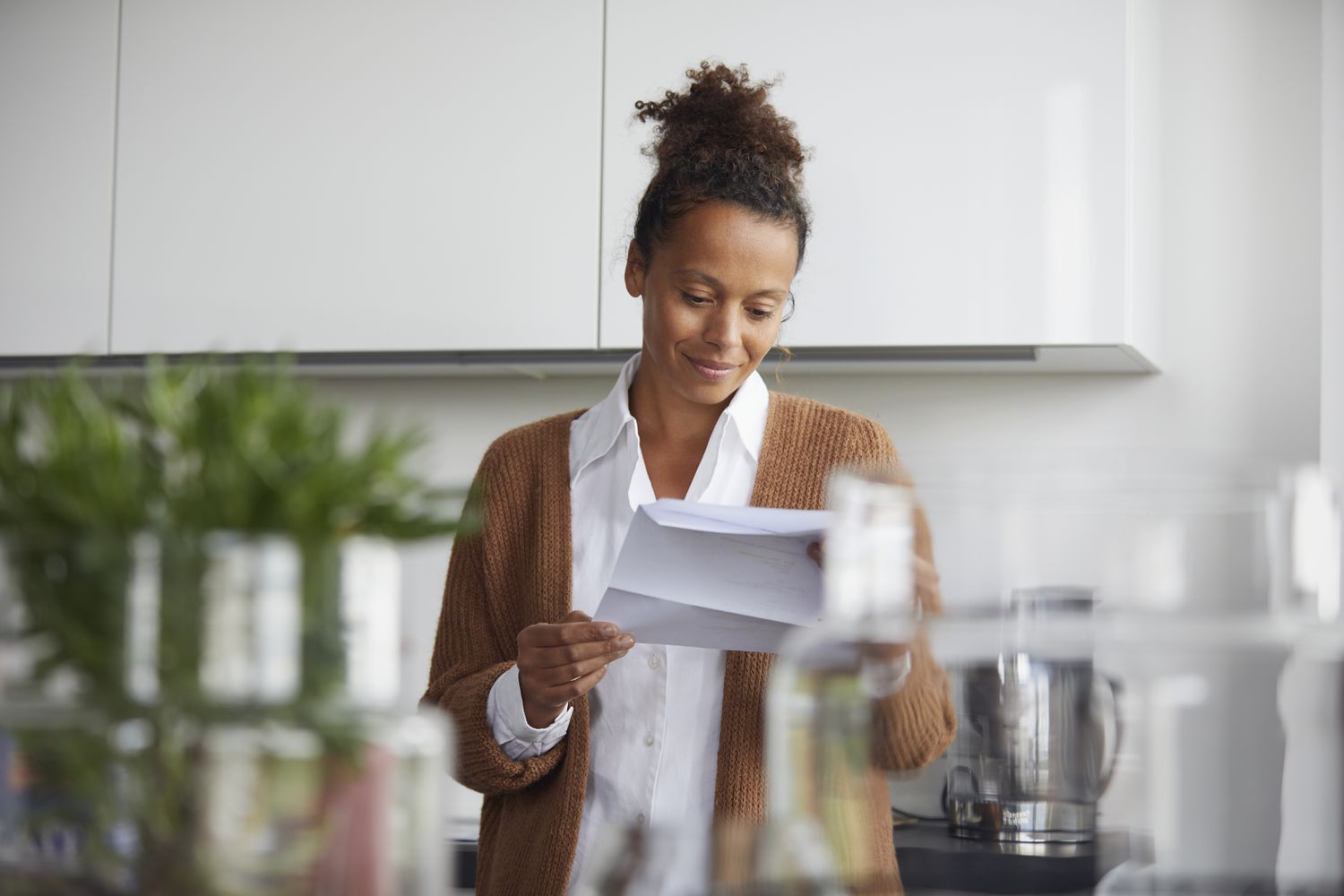 A woman stands in her kitchen reading a statement