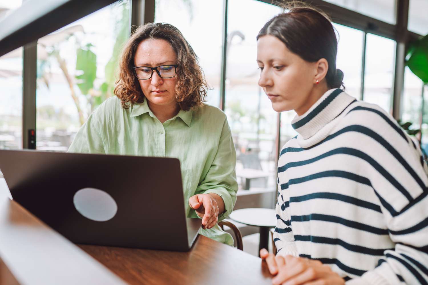 A financial advisor shows a client a screen on a laptop and explains sub-asset class investments.