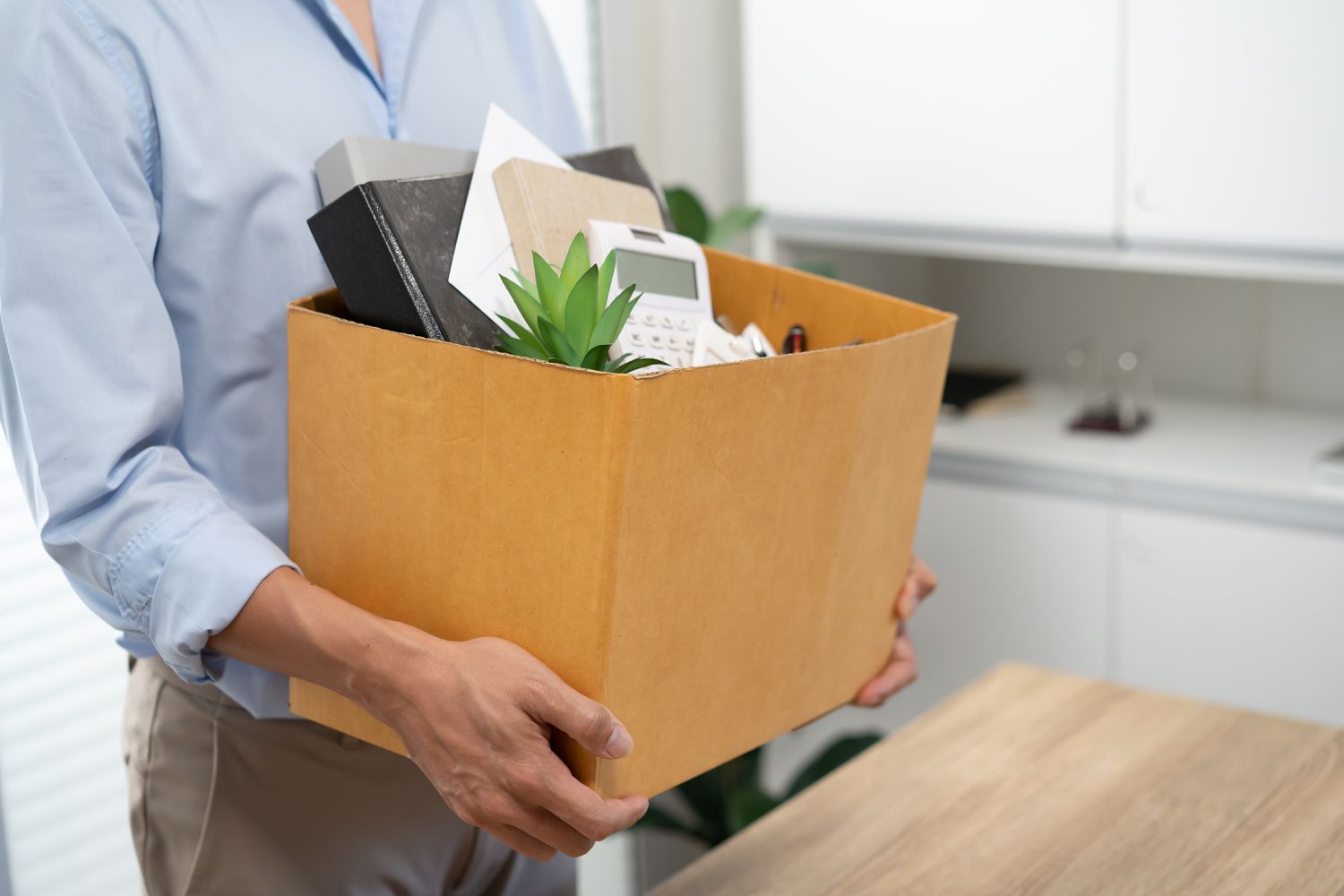Worker with box of belongings leaving job