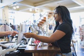 A woman pays for items in a store with a credit card.