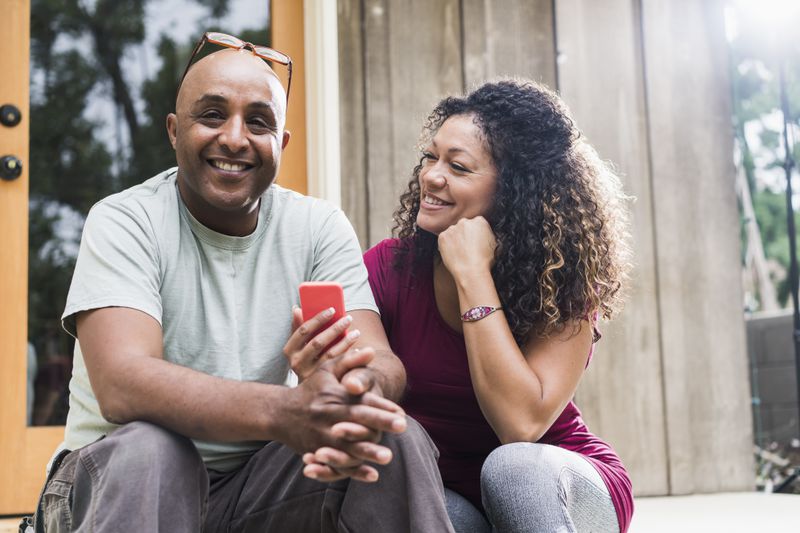 Smiling couple sitting outdoors on steps