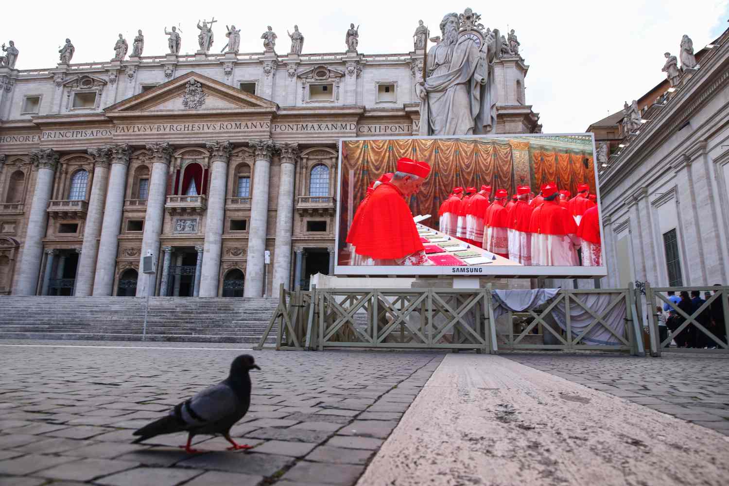 A large screen outside Saint Peter's Basilica shows a live stream of cardinals gathered at the start of the conclave.