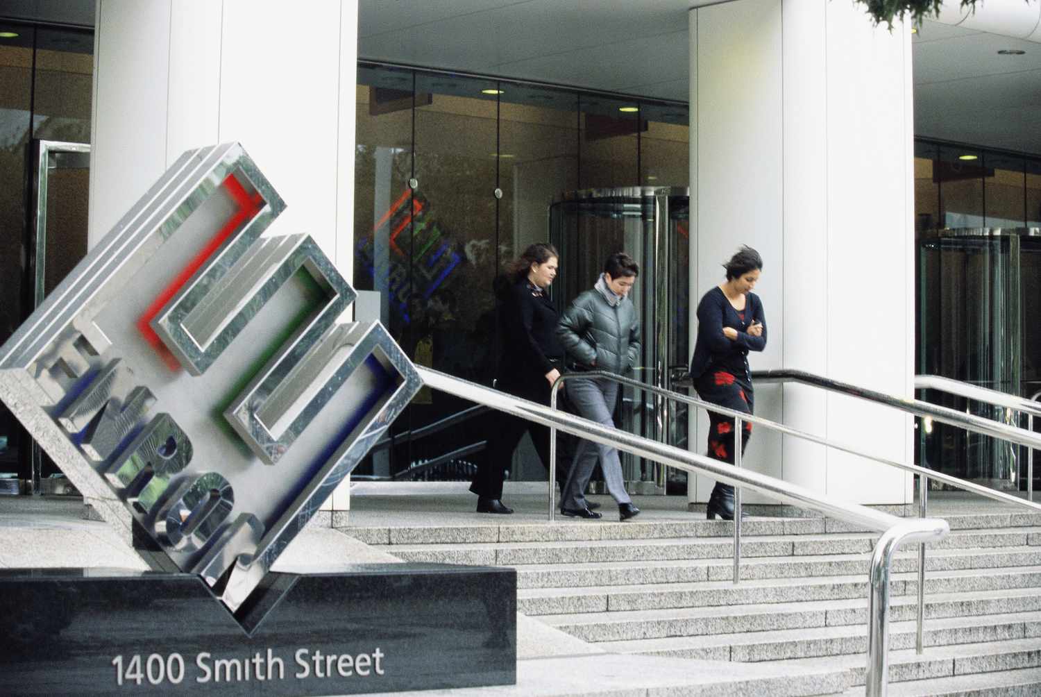 Front view of Enron Headquarters with people walking out of the building