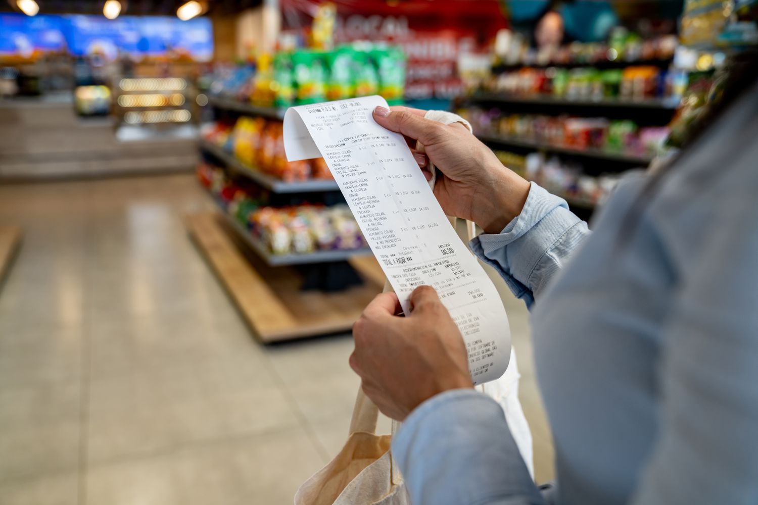 A stock image of a shopper looking at a receipt. 