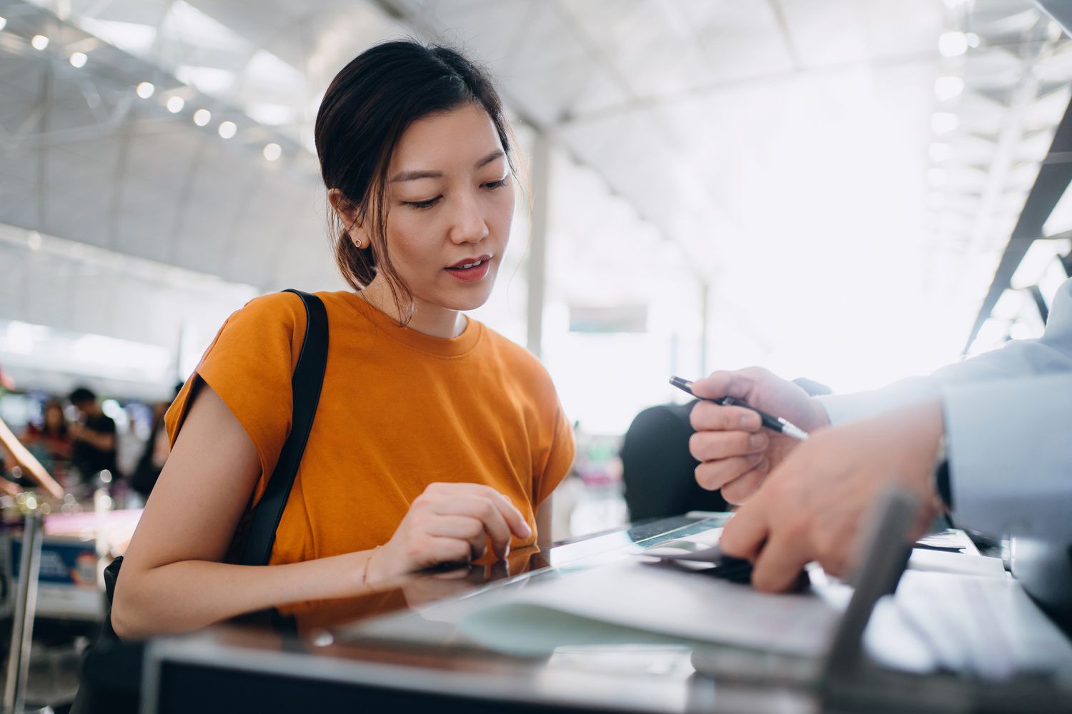 Young asian woman at a customs desk and airline check in. 