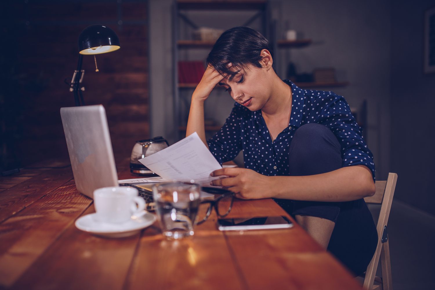 A woman reading documents at a table.