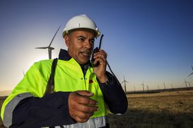 A workman in front of windmills