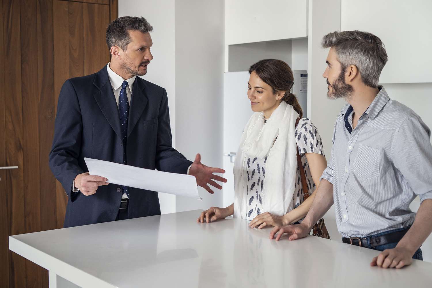 Real estate agent discussing documents with couple in new house