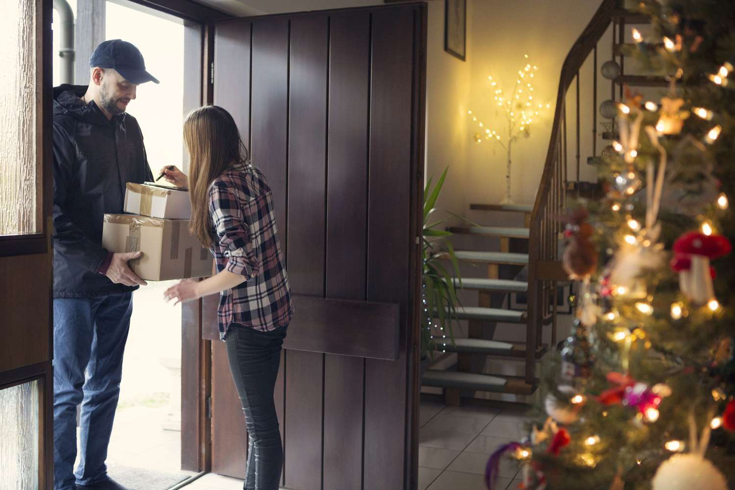 A teenager receiving Christmas packages delivered by the postman.