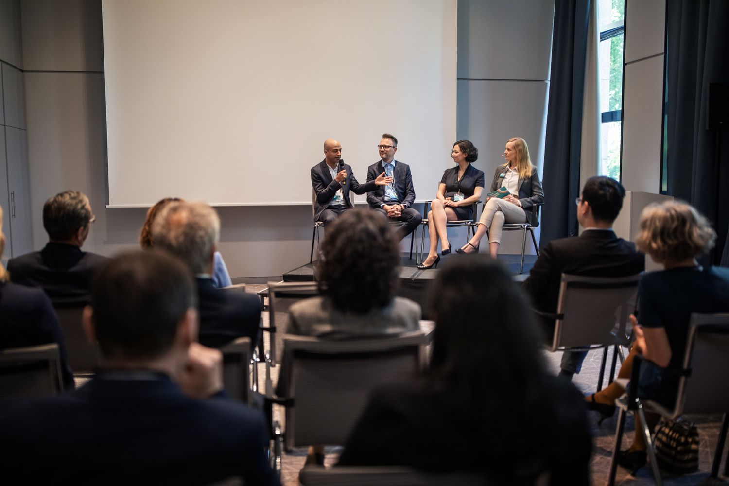 An audience listens to a group of presenters on stage during a SCORE business seminar.