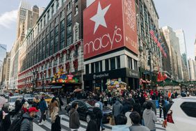 People and cars are seen on the street outside the flagship Macy's store in New York City.