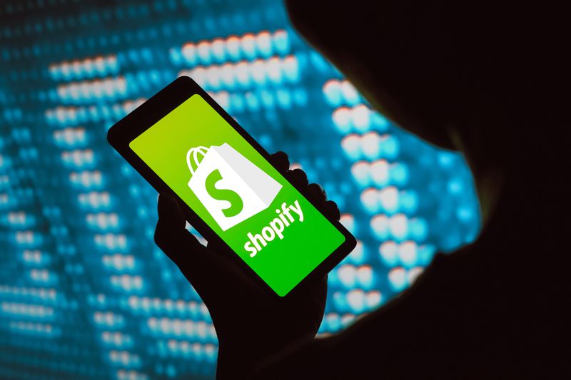 The Shopify logo is displayed on a smartphone screen