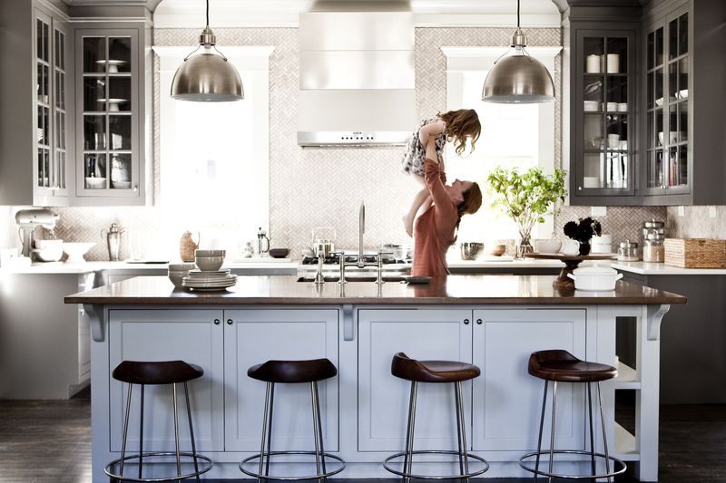 Mother lifting daughter in kitchen