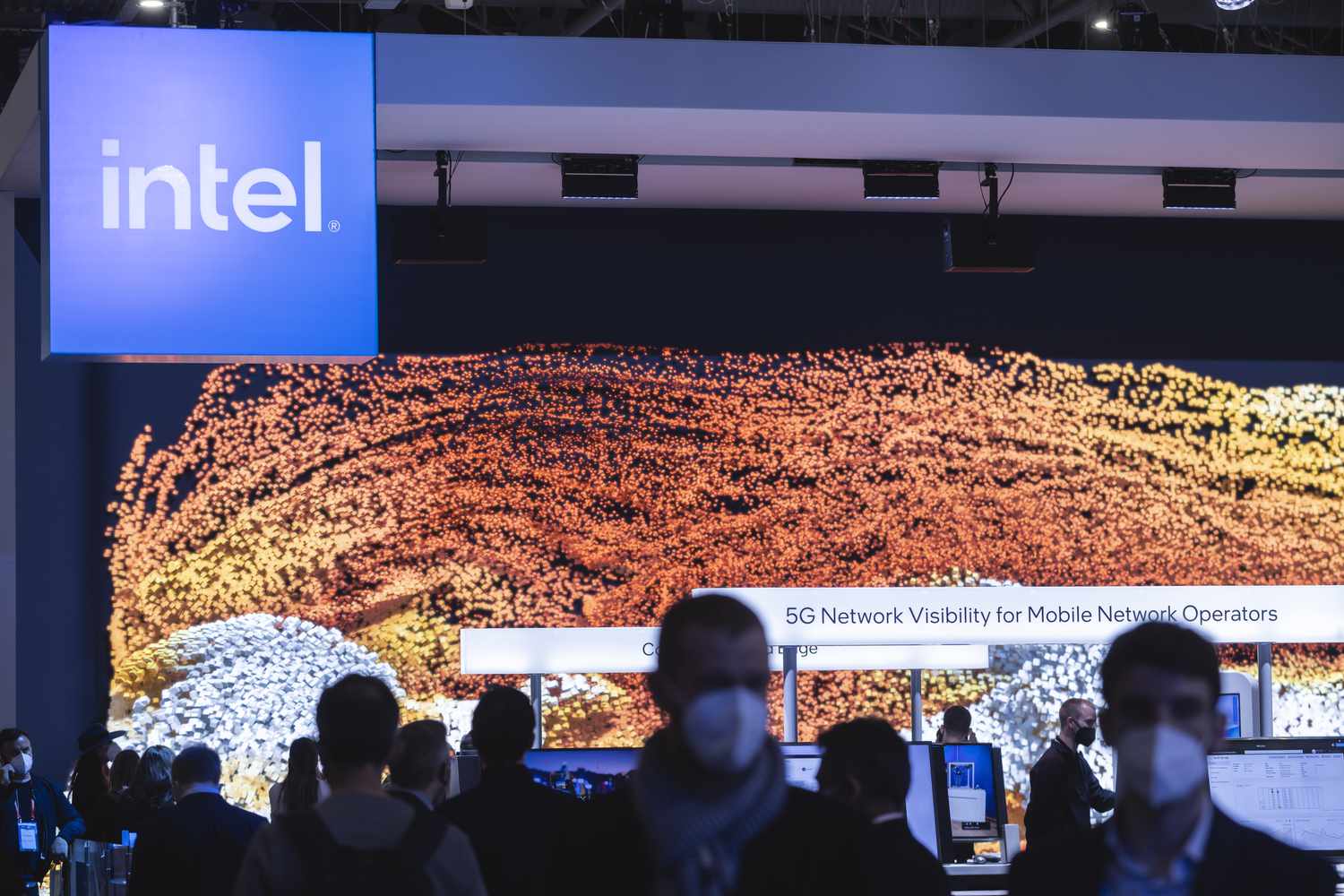 Intel logo hangs above crowd in conference center.