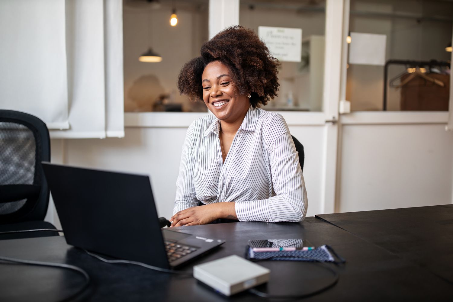 Businessperson in an office on a video call using a laptop