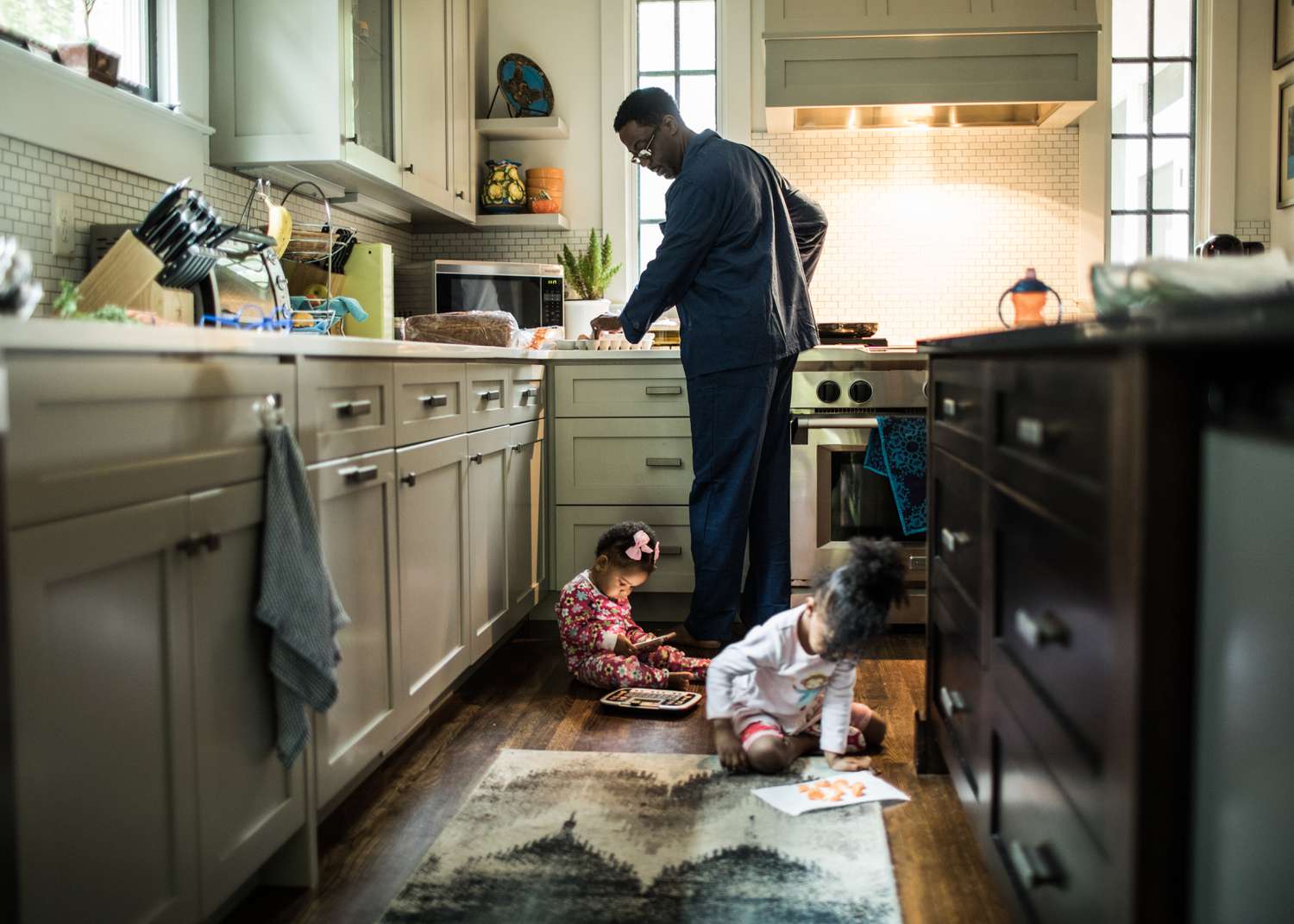 Father cooking breakfast for daughters in kitchen.