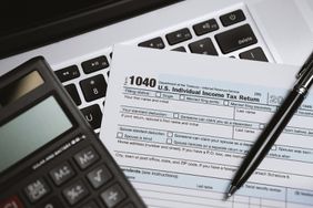 Printed Tax Form on Laptop With Calculator and Pen