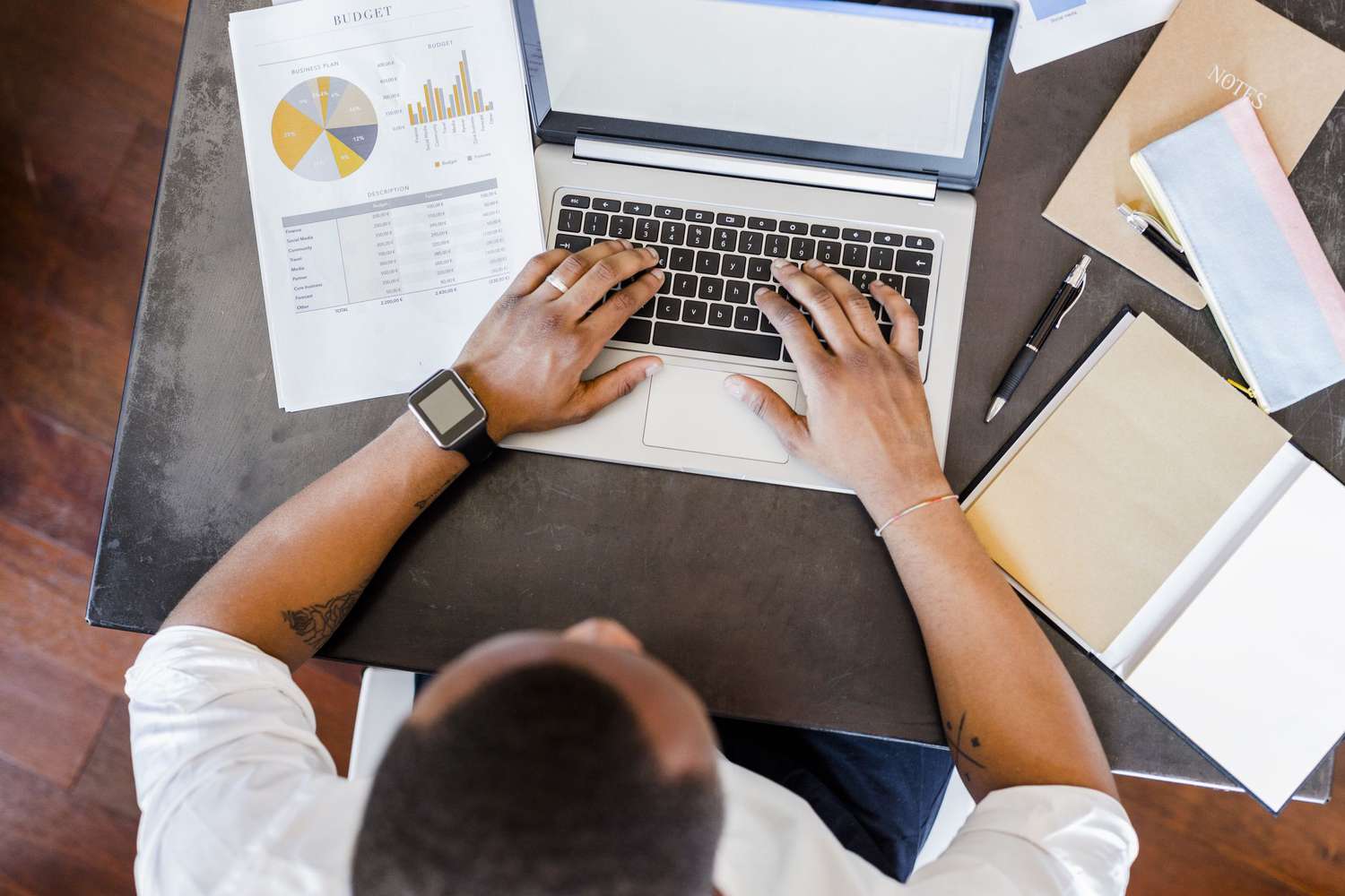 Man using laptop at desk in home office.