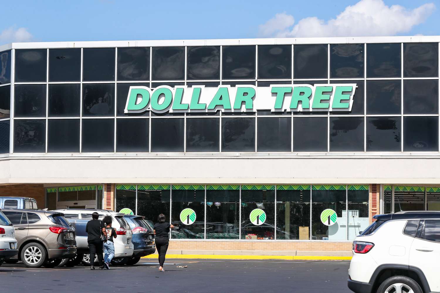 People and cars are seen outside of a Dollar Tree store.