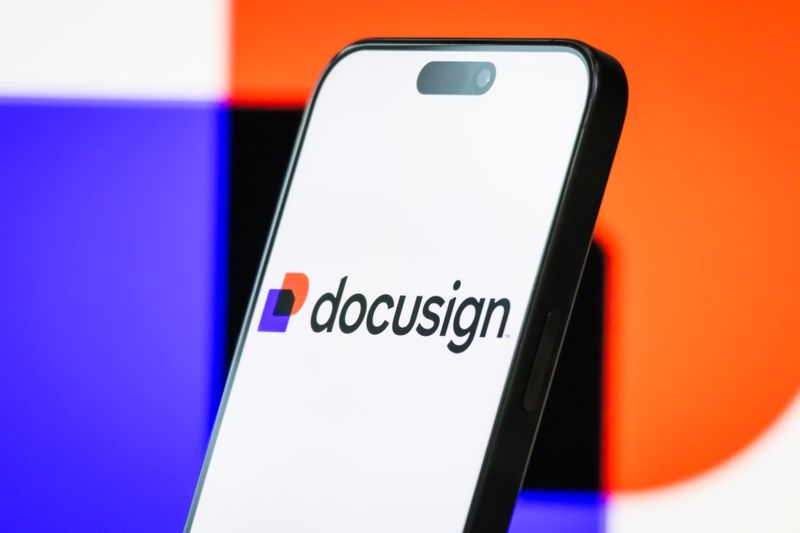 The logo of DocuSign, Inc. is displayed on a smartphone screen, with the company's branding colors visible in the background