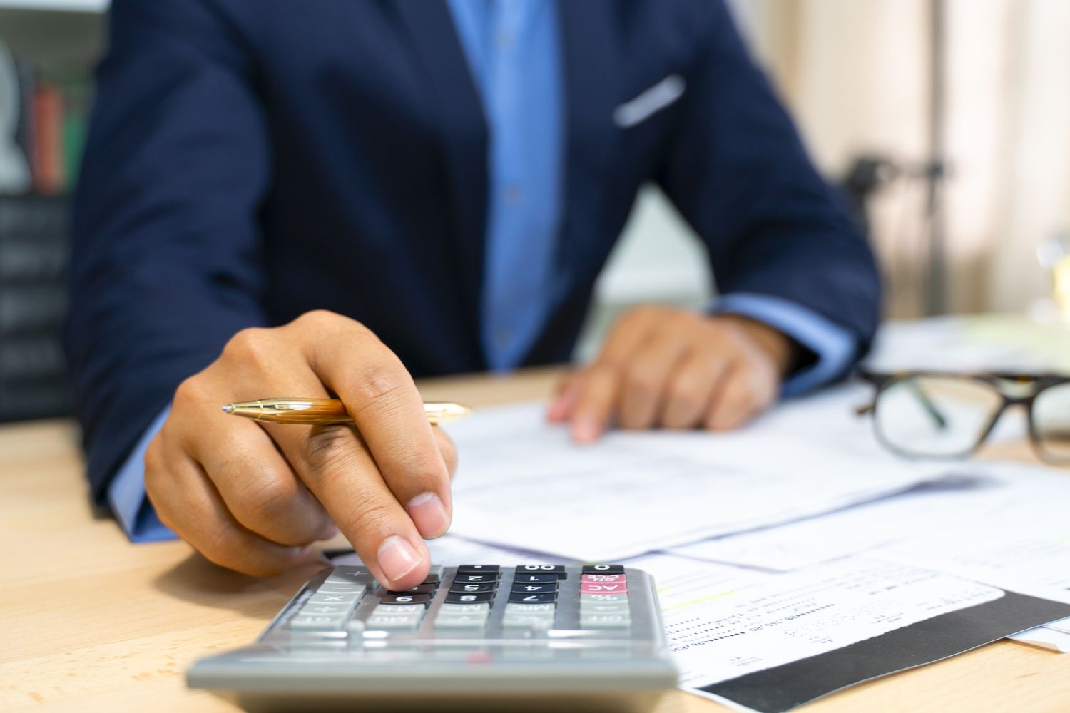 Hands of bank officer calculating loans.
