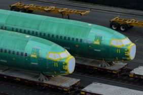 A pair of green, in-progress Boeing 737 Max fuselages are seen on train tracks.