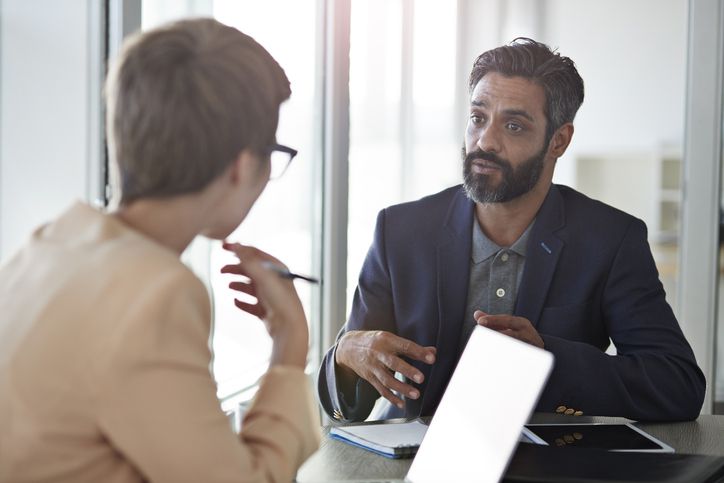Two coworkers talking in a meeting room