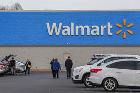People and cars are seen outside of a Walmart store.