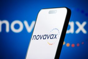 The logo of Novavax, Inc. is displayed on a smartphone screen, with the company's colorful circular branding visible in the background