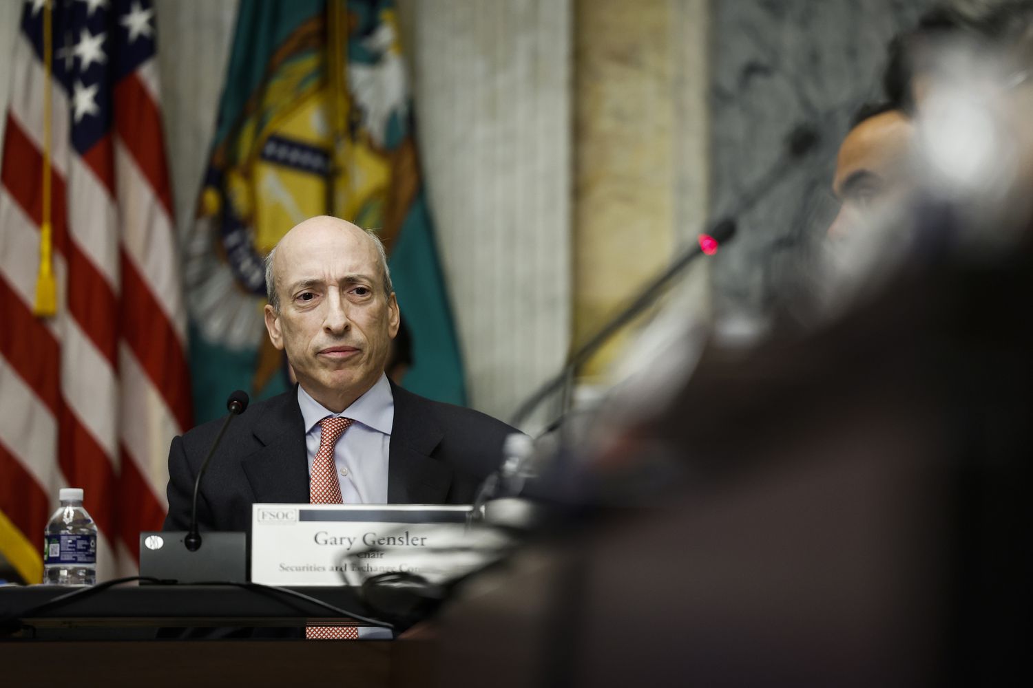Gary Gensler sits in a committee hearing