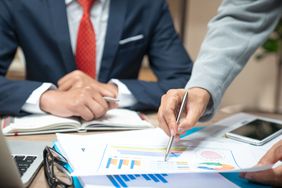 A business meeting analyzing and discussing the situation on the financial report in the meeting room.