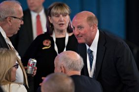 Greg Abel, chairman and chief executive officer of Berkshire Hathaway Energy Co., right, speaks with attendees before the start of the Berkshire Hathaway Inc. annual meeting in Omaha, Nebraska, U.S., on Saturday, May 6, 2017. 