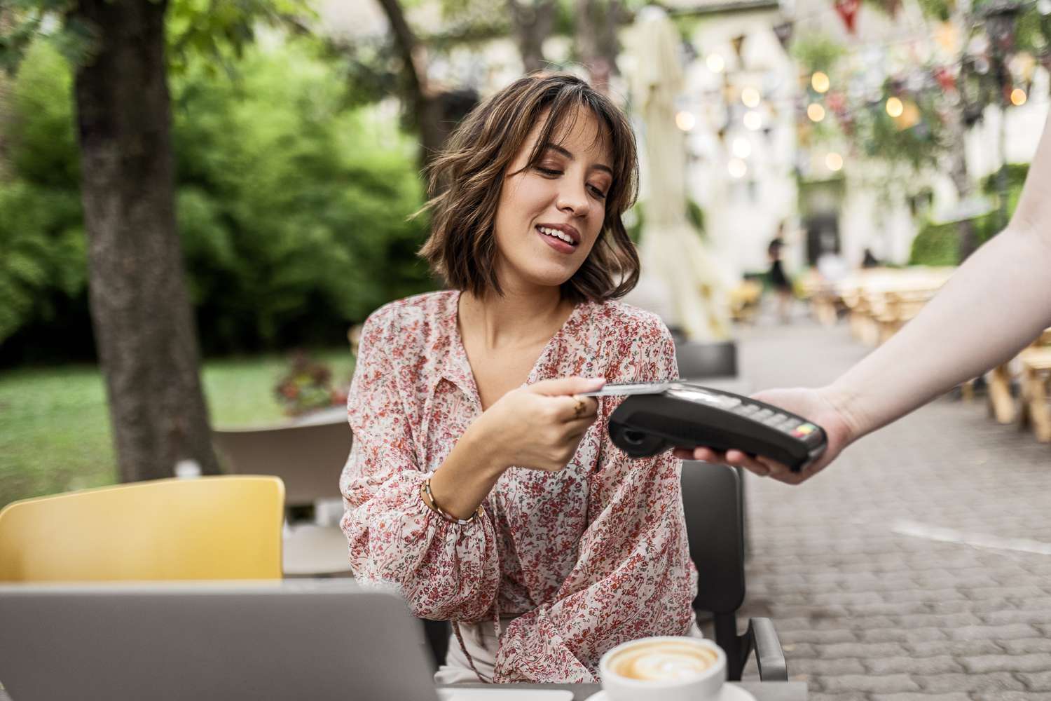A person using credit card to pay for coffee to a card machine.