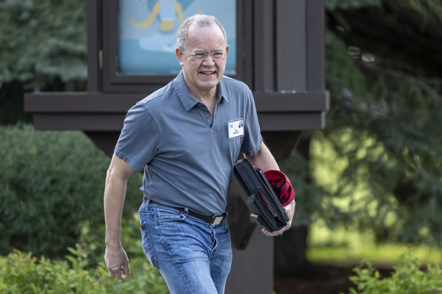 Ted Weschler holding some files and a laptop as he is walking