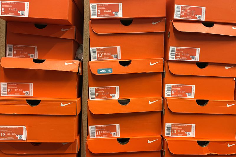 Stacks of Nike shoe boxes sit on a shelf at a shoe store.