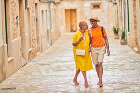 Two female tourists walking down a street in Spain