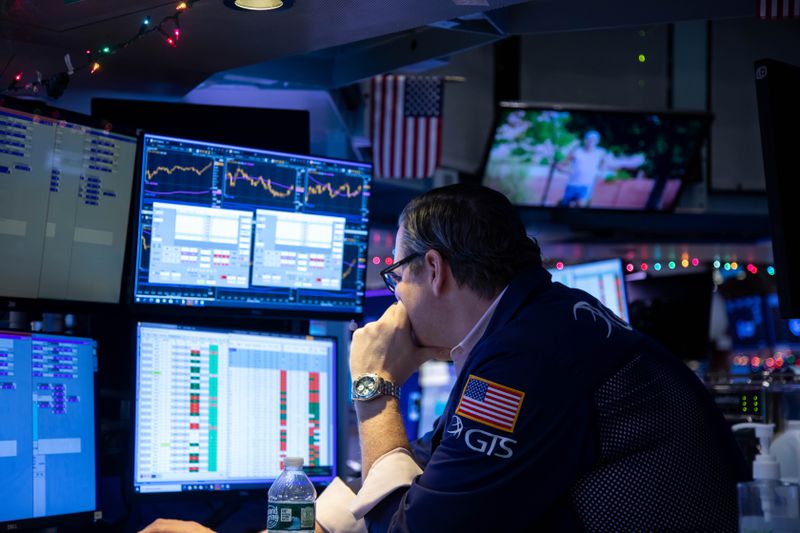 A trader leans his head on his hand as he looks at screens at the New York Stock Exchange