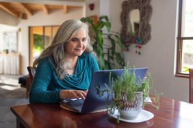 Homeowner sits at home searching on laptop about HELOC options.