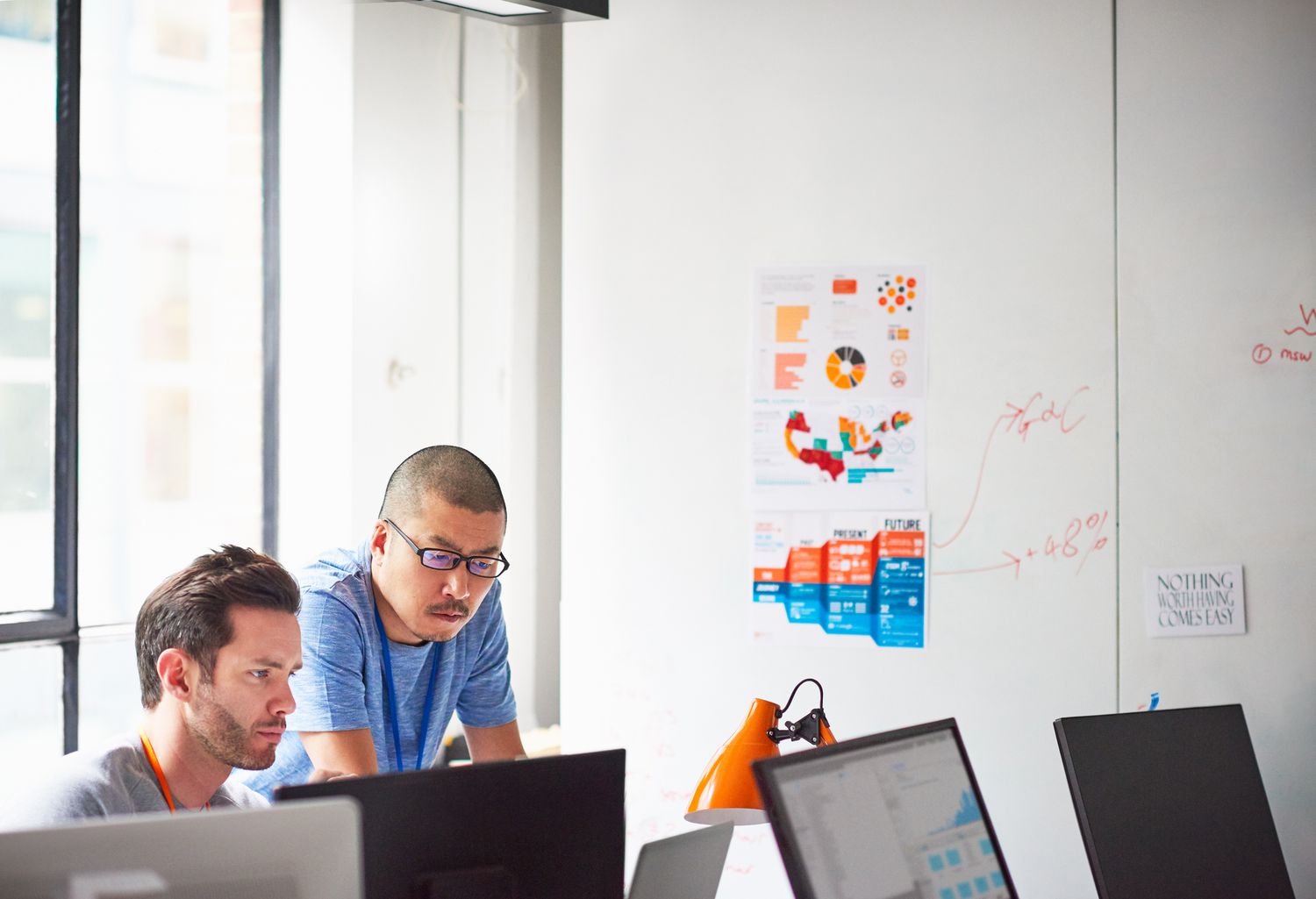 Two businessmen working together at the computer