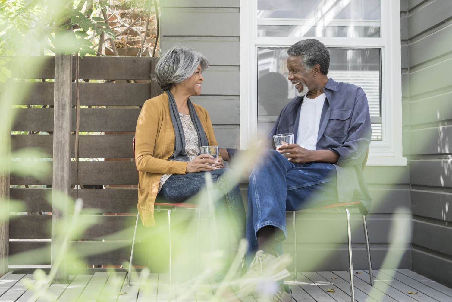 An older couple enjoys coffee on their porch.