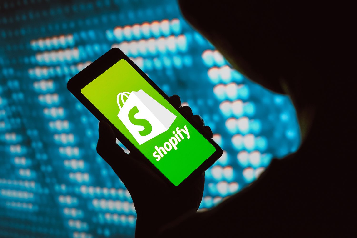 The Shopify logo is displayed on a smartphone screen