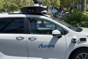 The blue Aurora logo is seen on the side of a self-driving vehicle from Aurora Innovation.