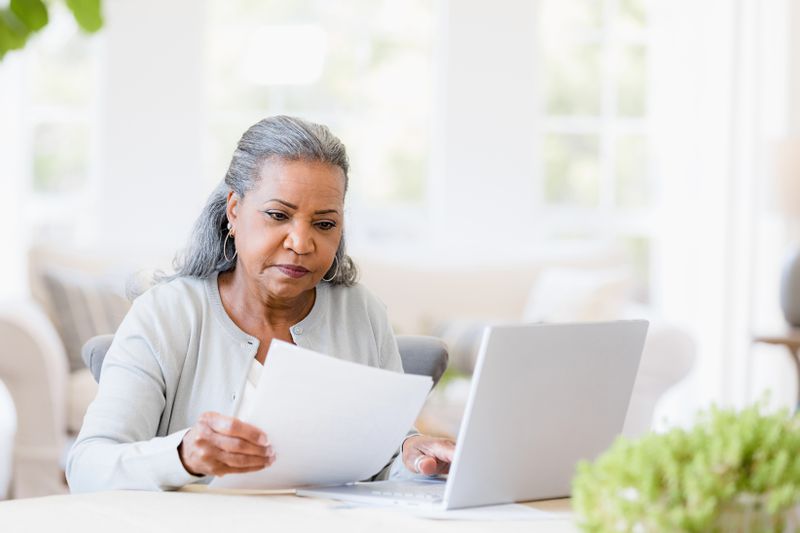 An woman reads documents at a desk.