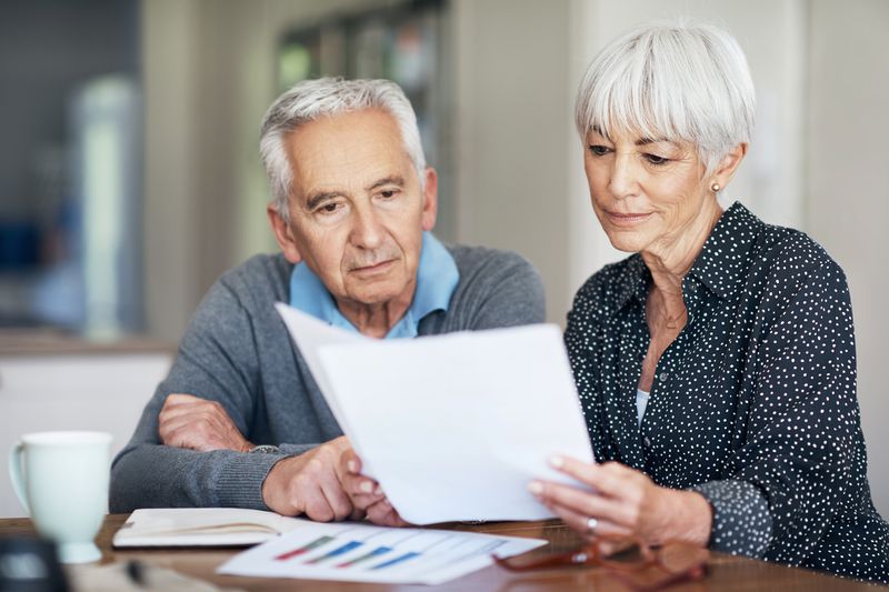 A couple going through their finances while sitting at the dining room table.