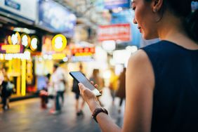 Young Woman Using a Smartphone in Busy City Street