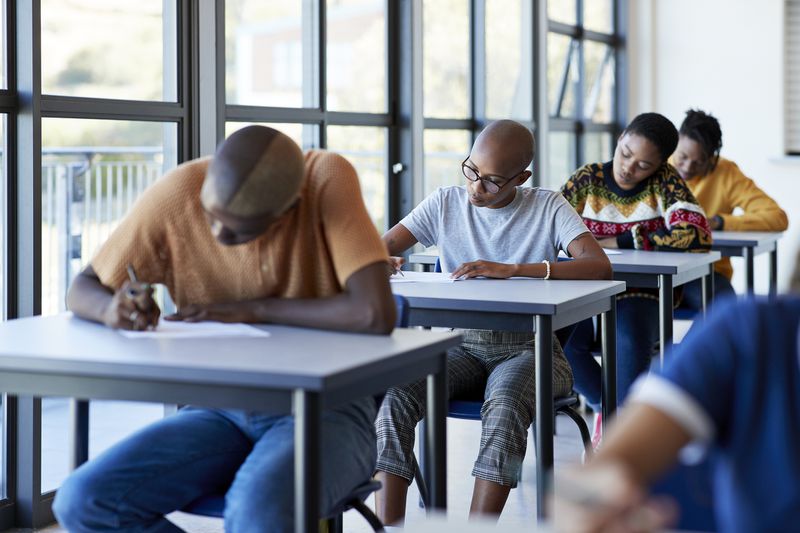 University students writing on papers at desks