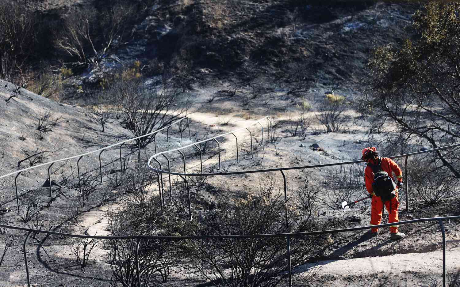 An inmate firefighter works to put out hot spots in a California wildfire.
