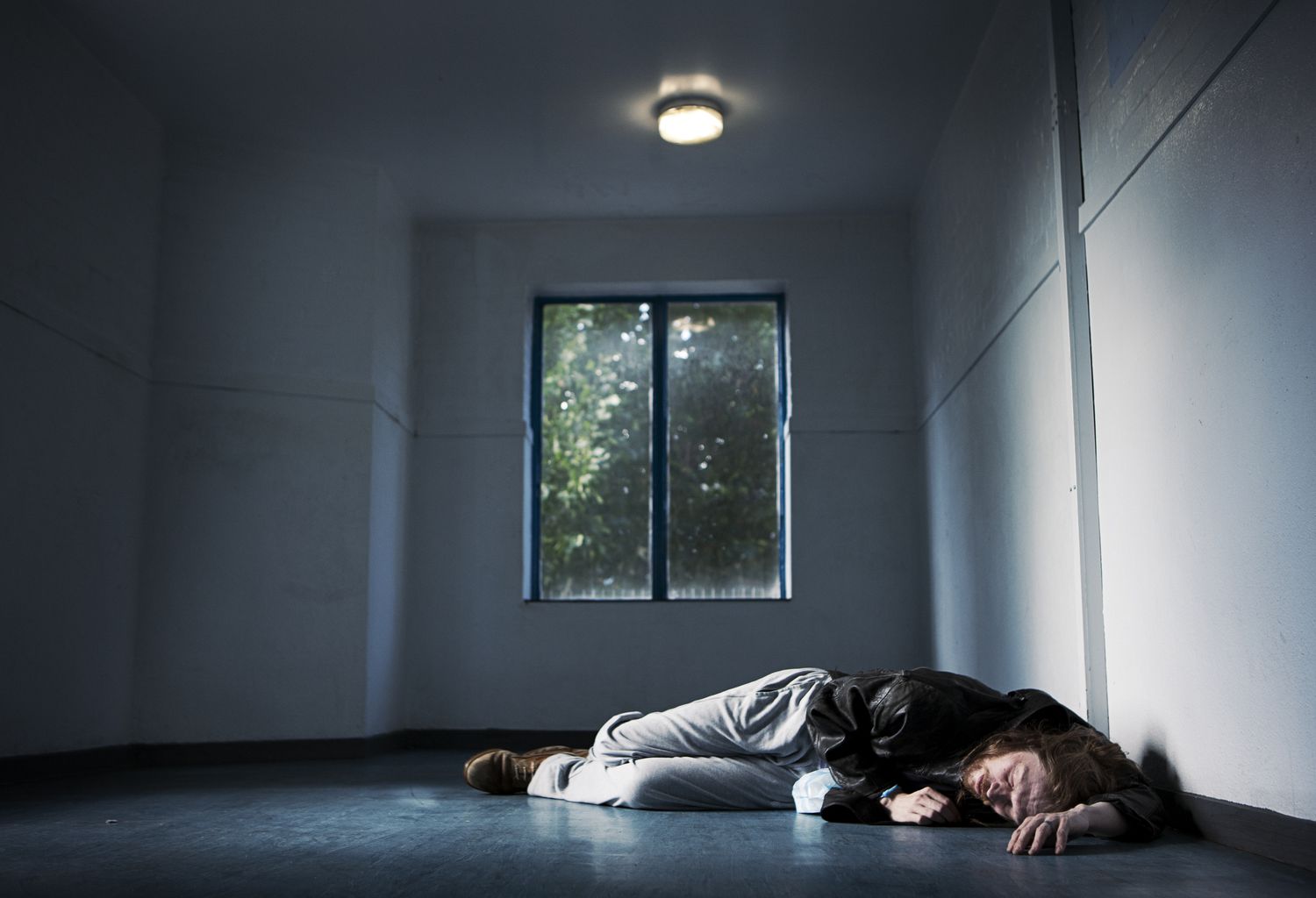 Man laying on floor in empty room.