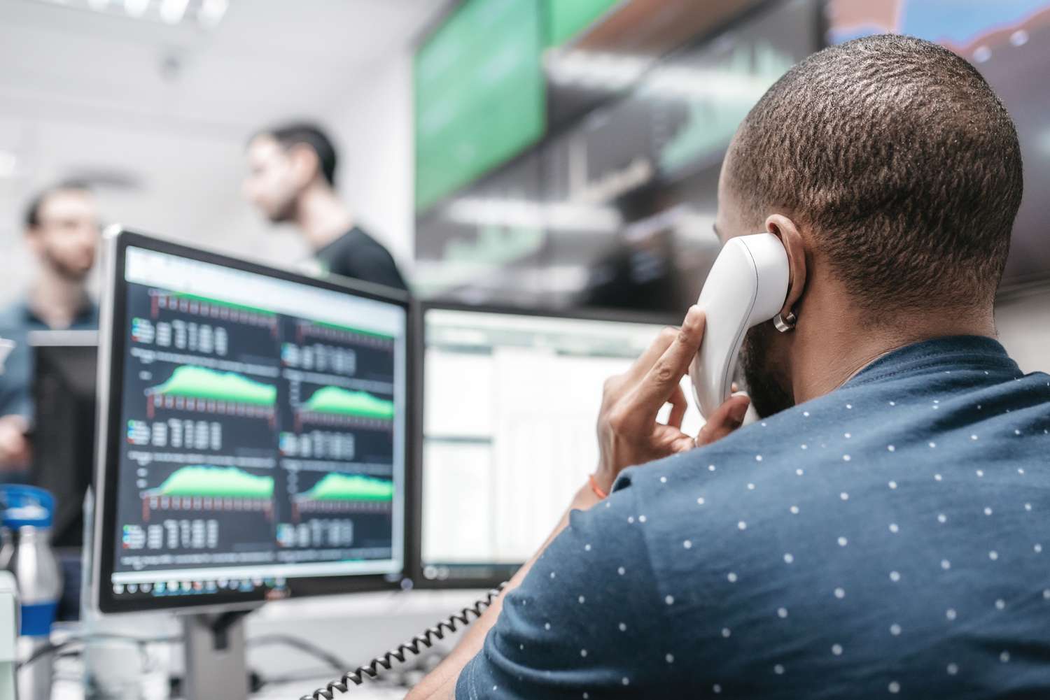A worried investor on the phone with their broker trying to stop an order to sell holdings based on a price drop after an earnings report.